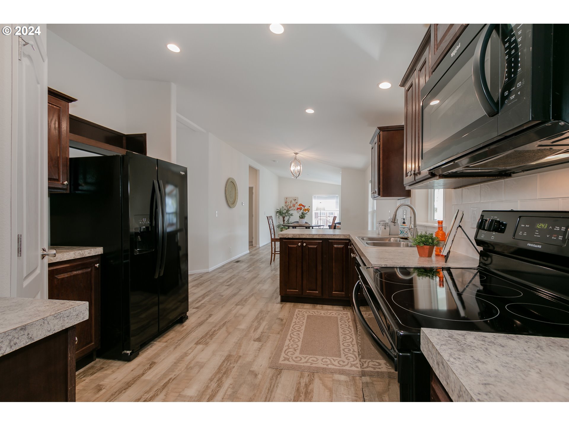 2150 Laura Street, Unit 94 Springfield, OR 97477 - Photo 15 of 28 a kitchen with stainless steel appliances kitchen island granite countertop a refrigerator stove and sink