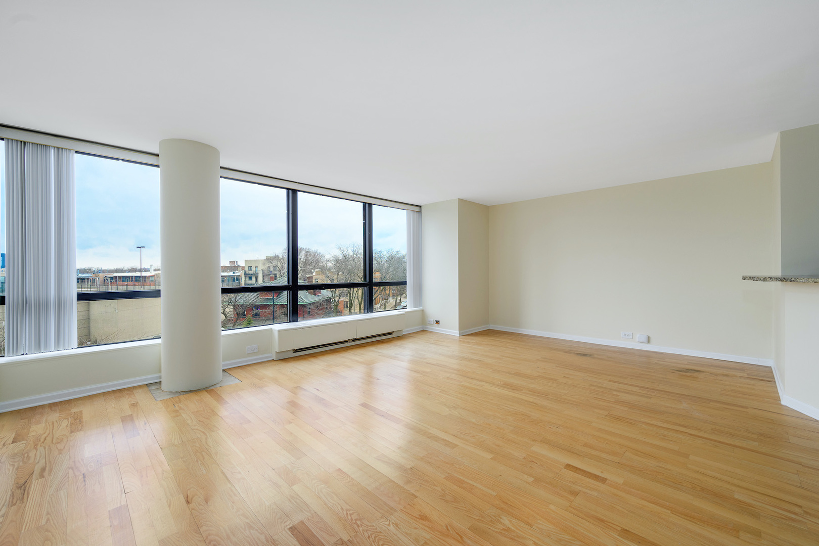 5415 North Sheridan Road, Unit 412 Chicago, IL 60640 - Photo 6 of 22 an empty room with wooden floor and windows