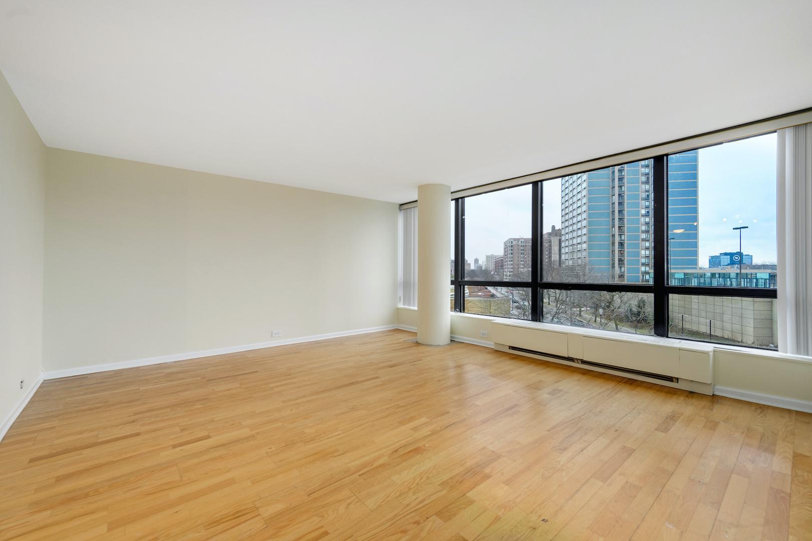 5415 North Sheridan Road, Unit 412 Chicago, IL 60640 - Photo 8 of 22 wooden floor in an empty room with a window