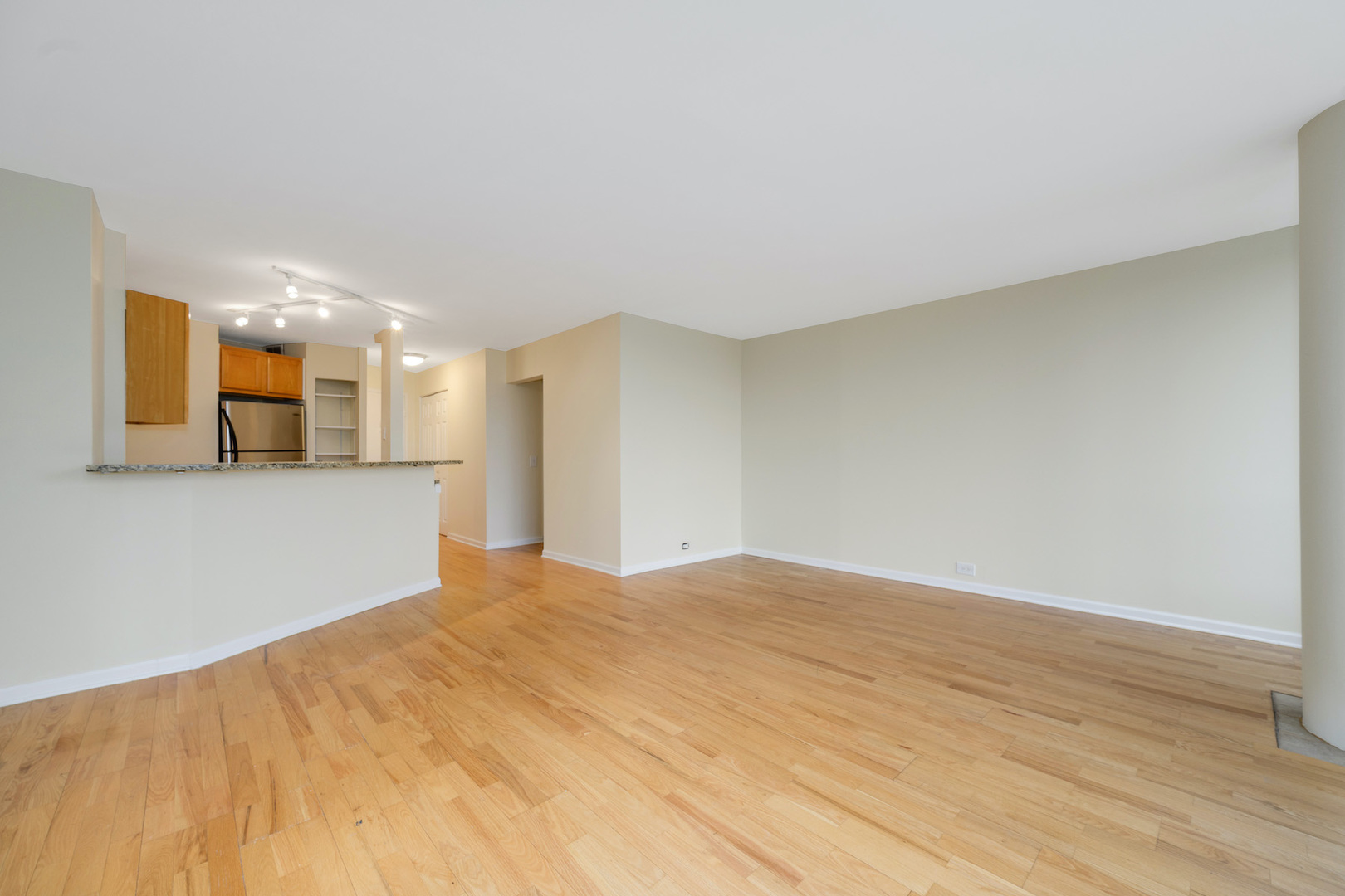 5415 North Sheridan Road, Unit 412 Chicago, IL 60640 - Photo 9 of 22 a view of a big room with wooden floor and a window