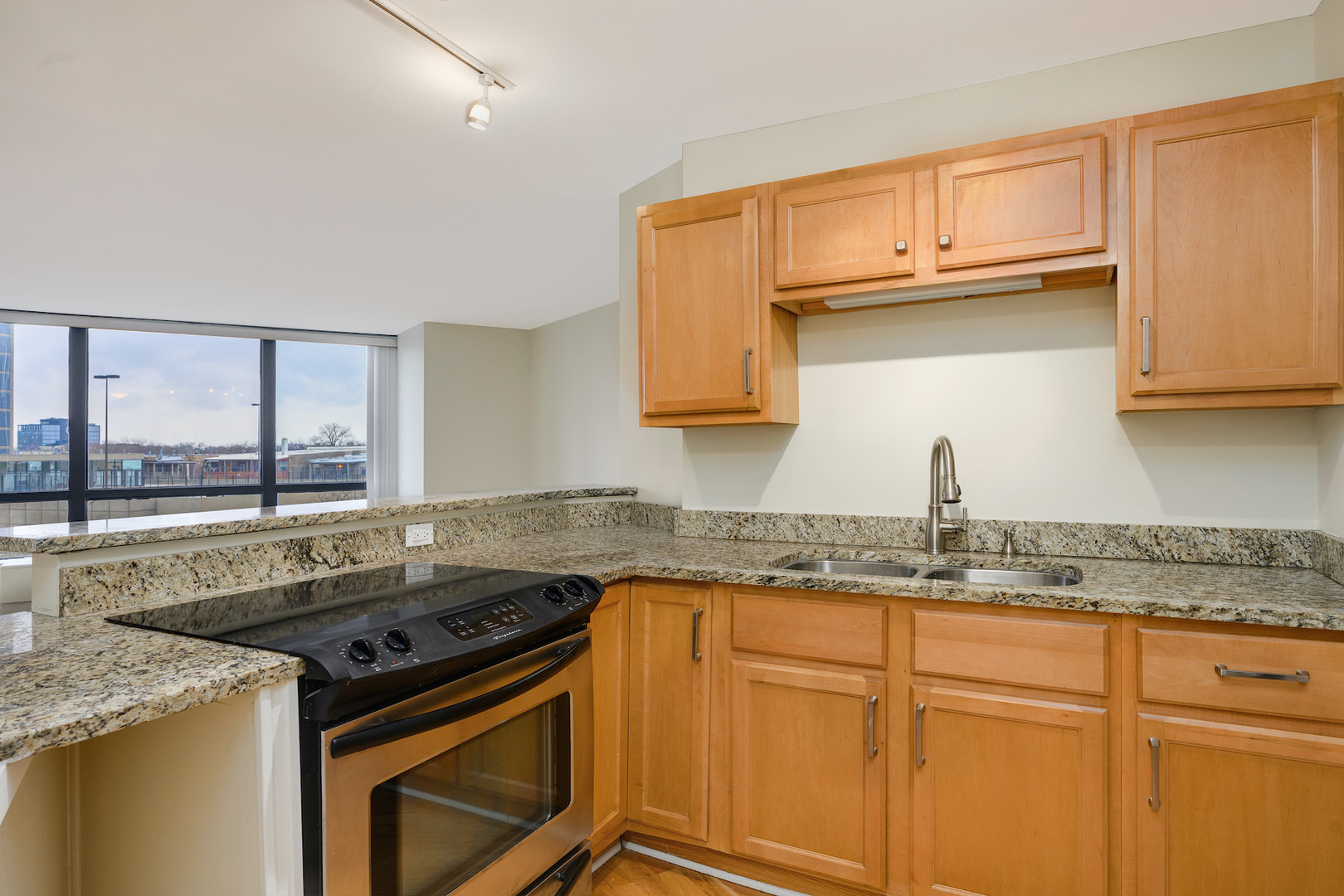 5415 North Sheridan Road, Unit 412 Chicago, IL 60640 - Photo 10 of 22 a kitchen with granite countertop a sink stove and cabinets