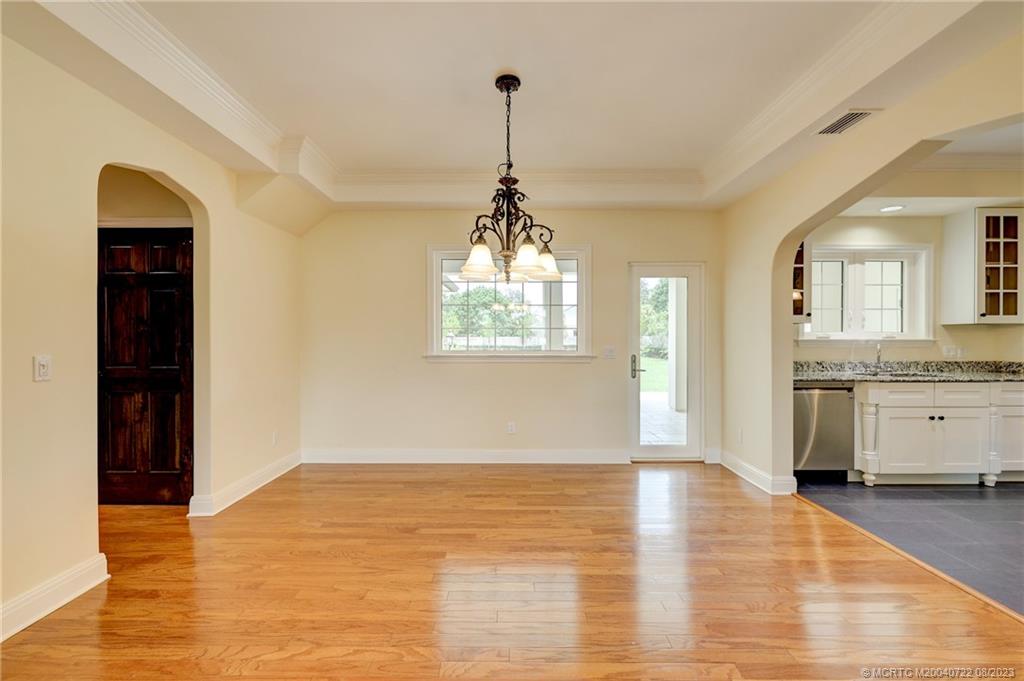 4865 Southeast Manatee Cove Road Stuart, FL 34997 - Photo 22 of 53 a view of a room with wooden floor and a ceiling fan