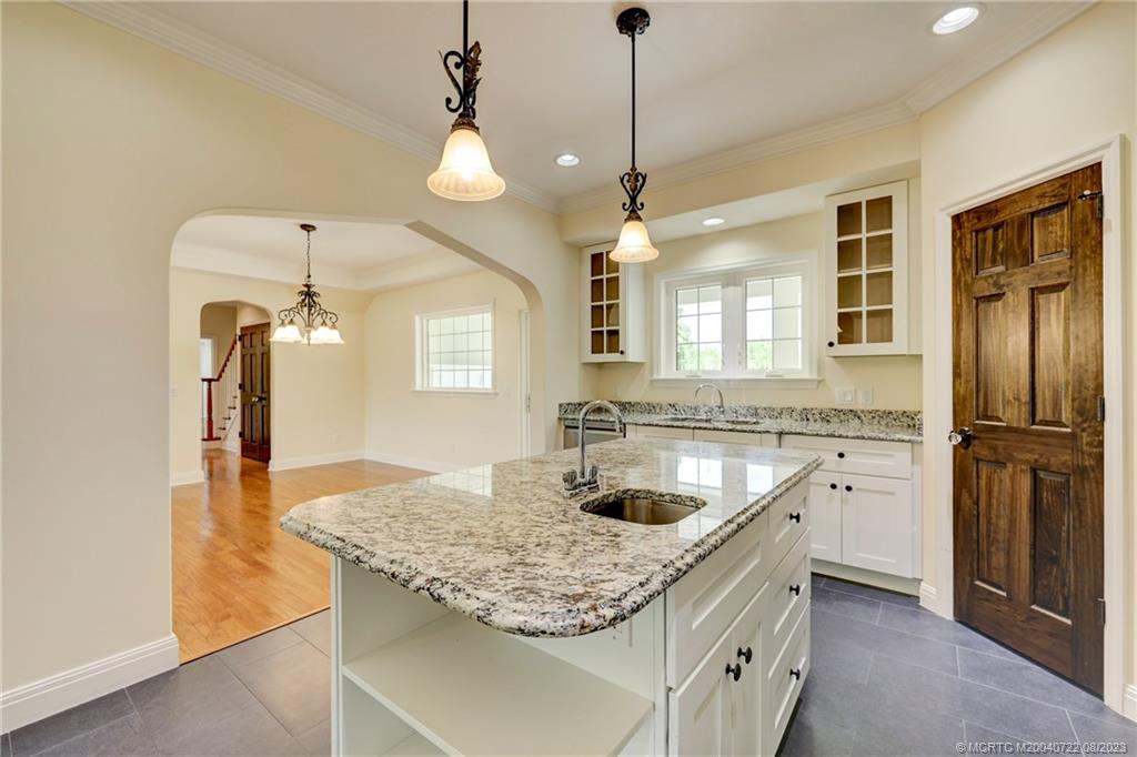 4865 Southeast Manatee Cove Road Stuart, FL 34997 - Photo 27 of 53 a kitchen with a sink a center island and cabinets