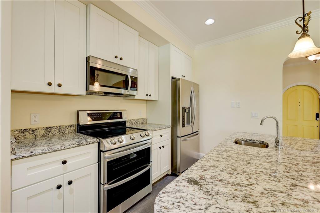 4865 Southeast Manatee Cove Road Stuart, FL 34997 - Photo 28 of 53 a kitchen with granite countertop a stove and a sink