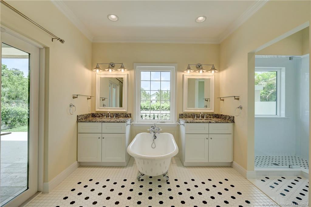 4865 Southeast Manatee Cove Road Stuart, FL 34997 - Photo 32 of 53 a bathroom with a sink a toilet a mirror a window and vanity