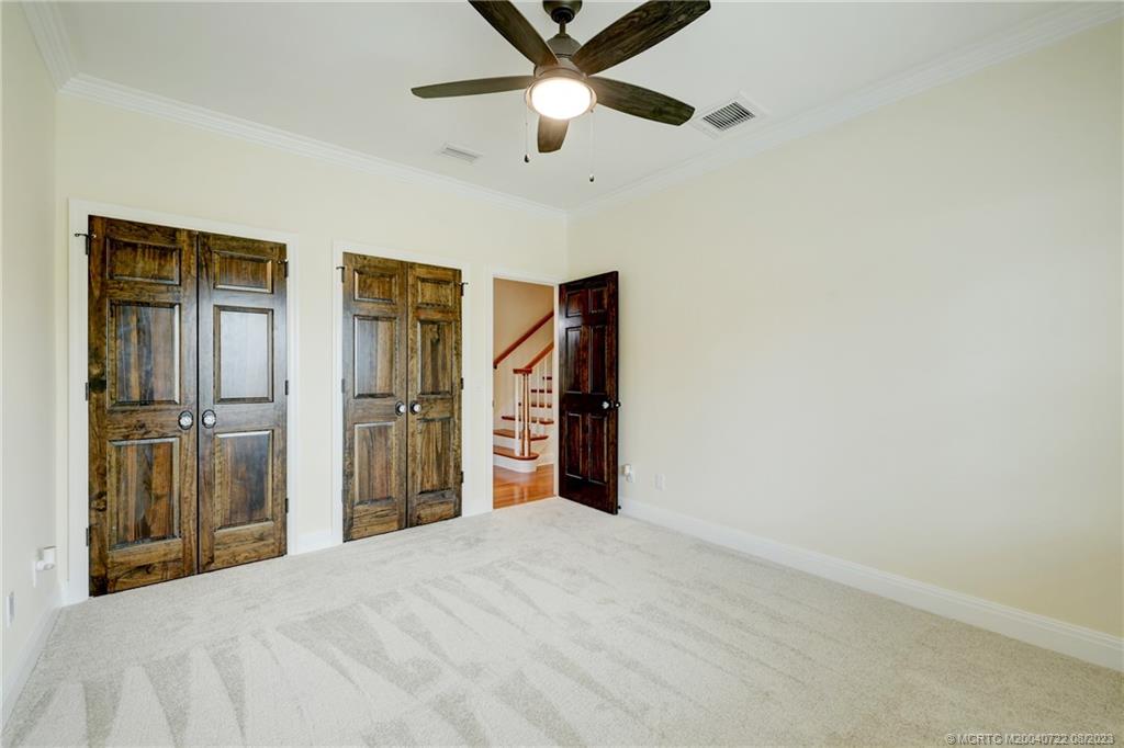 4865 Southeast Manatee Cove Road Stuart, FL 34997 - Photo 38 of 53 a bedroom with a bed and a chandelier