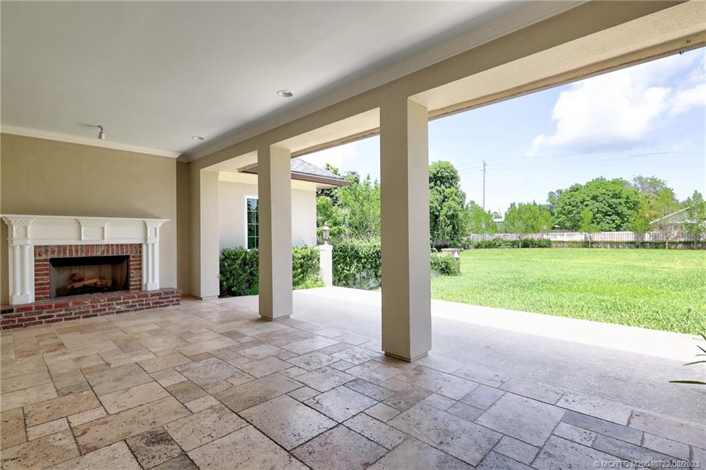 4865 Southeast Manatee Cove Road Stuart, FL 34997 - Photo 8 of 53 a view of an empty room with a fireplace and a large window