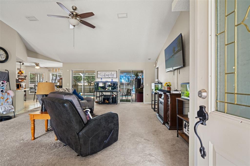 12292 Ronald Street Spring Hill, FL 34609 - Photo 2 of 18 a living room with furniture a ceiling fan and a window