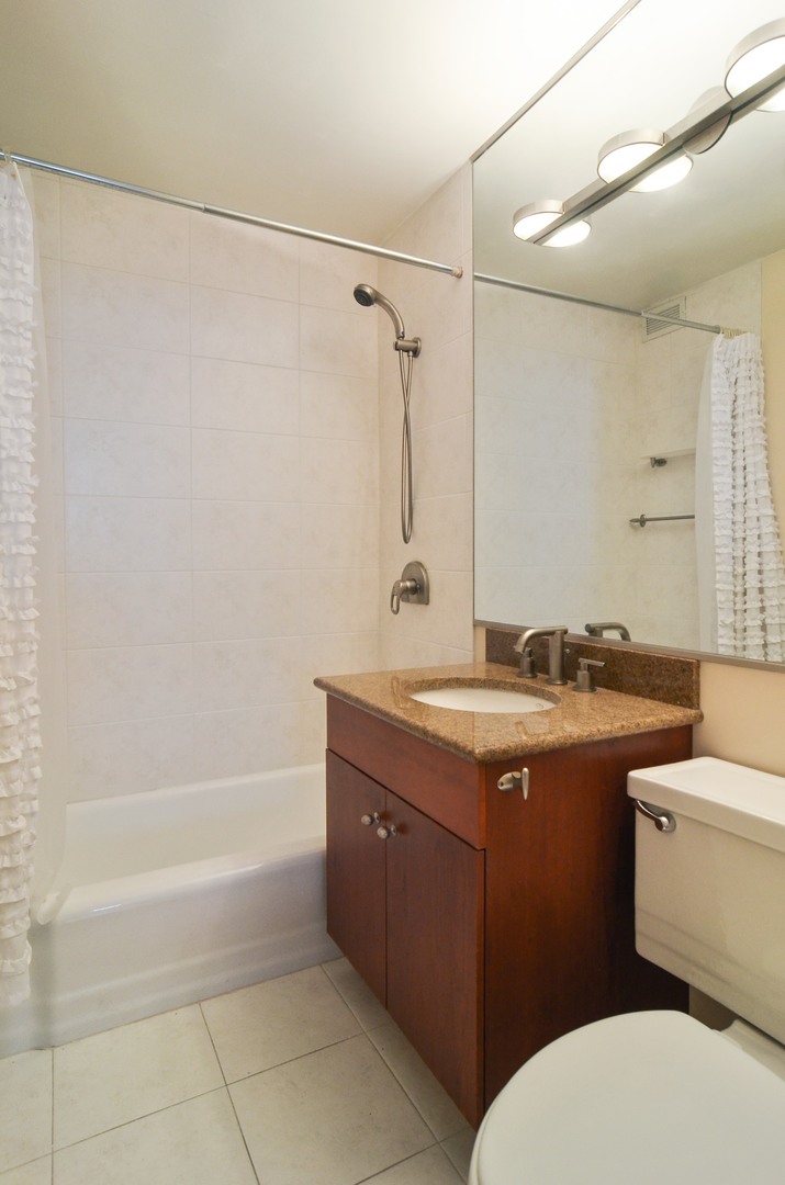 400 East Randolph Street, Unit 3404 Chicago, IL 60601 - Photo 8 of 35 a bathroom with a granite countertop sink a toilet and shower