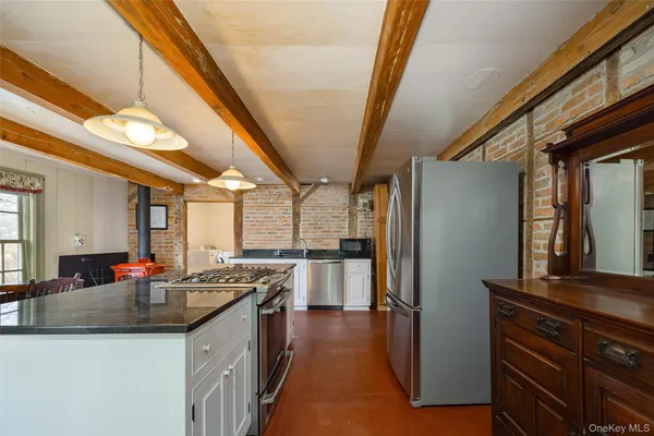 a kitchen with stainless steel appliances granite countertop a sink a stove and a refrigerator
