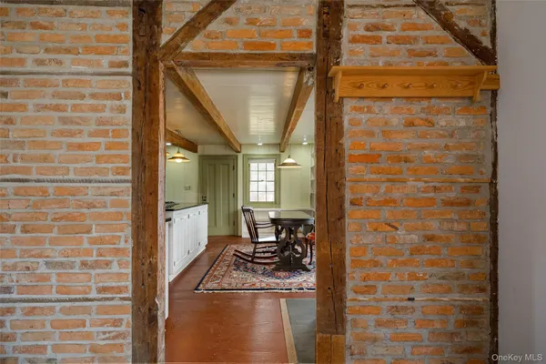 a view of a brick house with a chairs and table in a balcony
