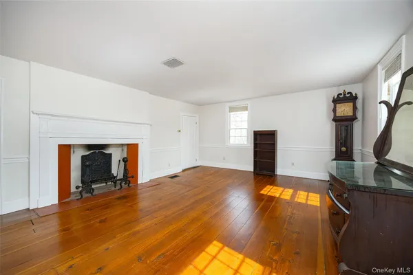 a view of empty room with wooden floor and fireplace