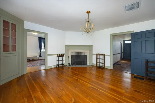 a view of a livingroom with wooden floor and a fireplace