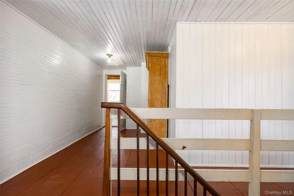 a view of staircase with railing and white walls