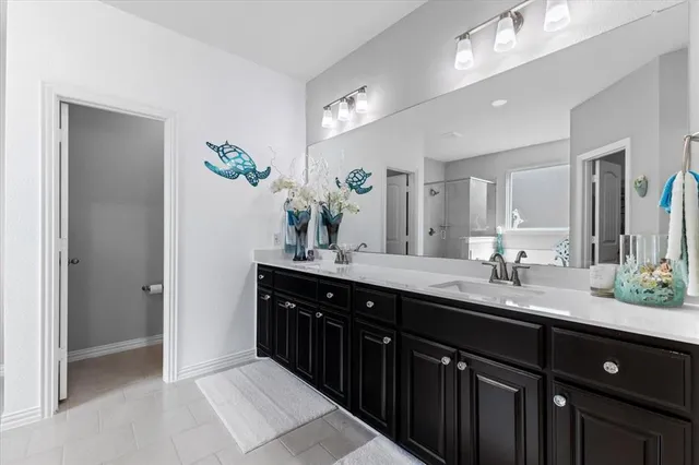 a spacious bathroom with a granite countertop sink a mirror and a shower