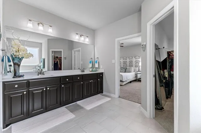 a spacious en suite bathroom with a sink and mirror