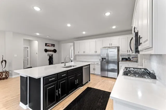 a kitchen with stainless steel appliances a sink stove and refrigerator