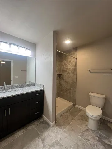 a spacious bathroom with a granite countertop sink a toilet and shower