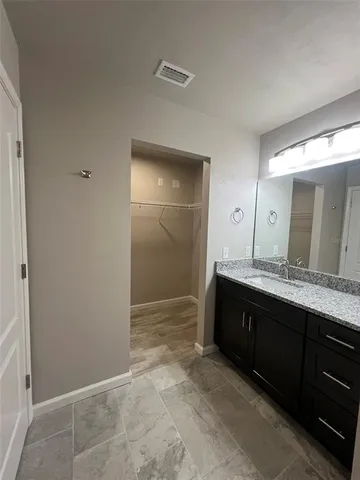 a bathroom with a granite countertop sink and a mirror
