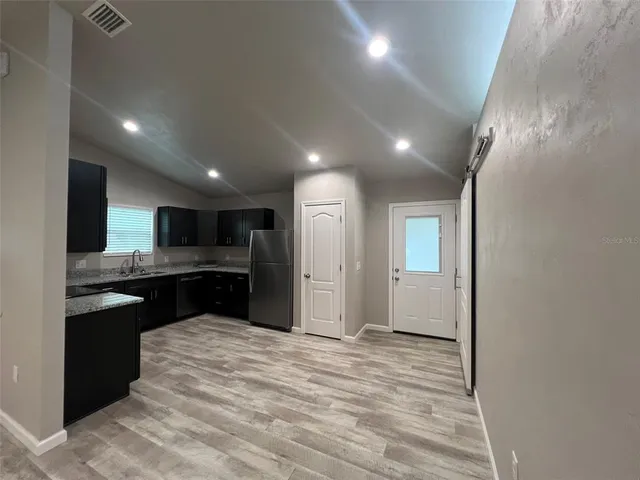 a view of kitchen with kitchen island stainless steel appliances counter space