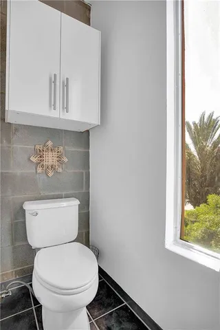 a white toilet sitting next to a window