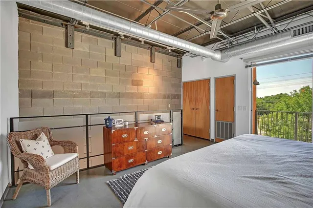 a bedroom with a bed next to a window