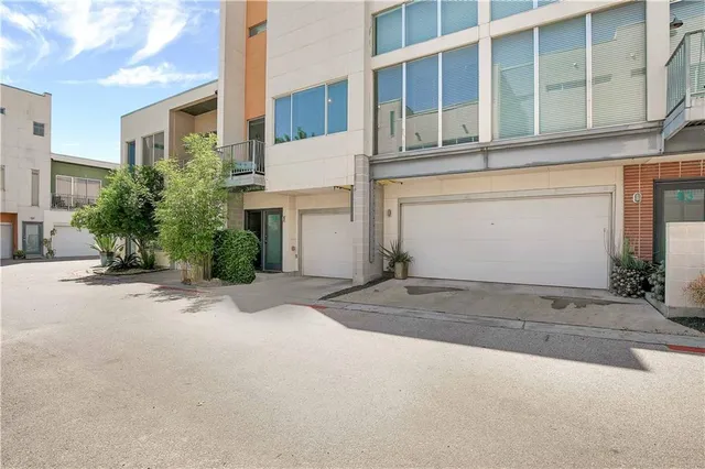 a front view of a house with a yard and potted plants