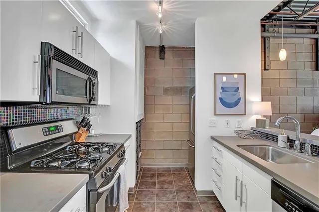 a kitchen with stainless steel appliances a stove sink and cabinets