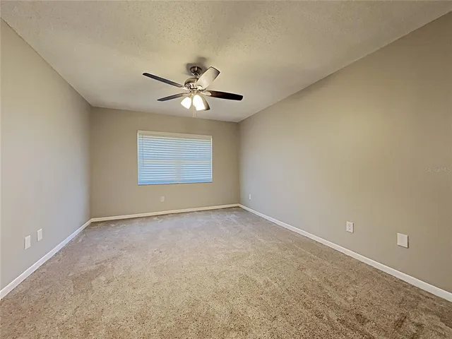 an empty room with a empty space and a ceiling fan