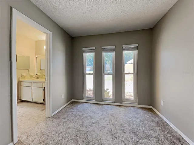 an empty room with windows and bathroom view