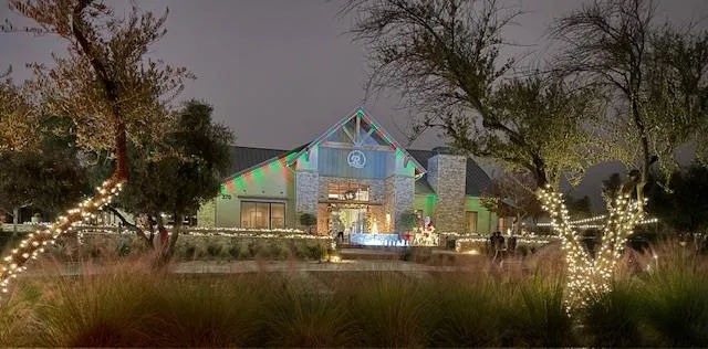 a front view of house with yard lake and trees in the background