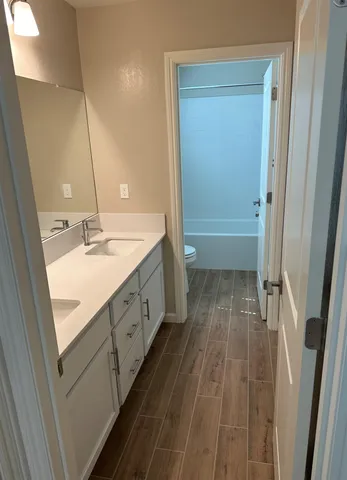 a spacious bathroom with a double vanity sink a mirror and a bathtub