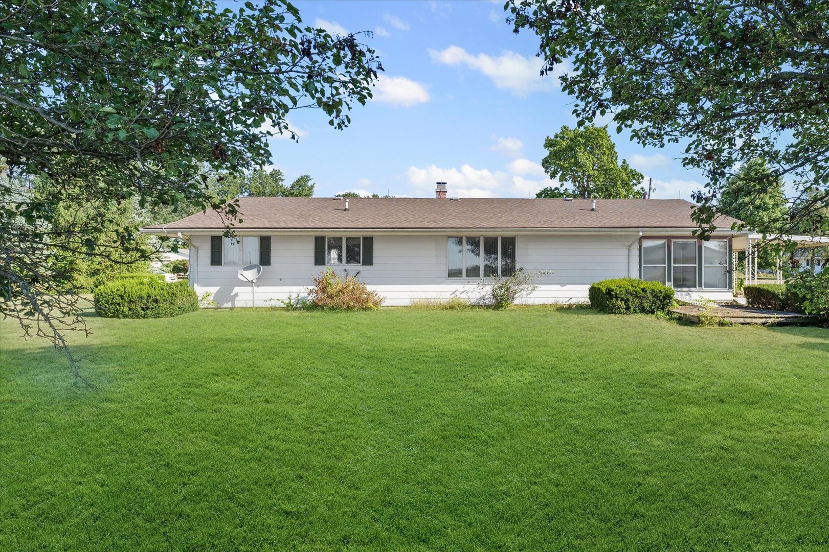 107 Walnut Street Penfield, IL 61862 - Photo 4 of 34 a front view of a house with garden and trees