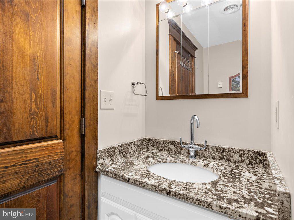 4404 Pine Top Road Madison, MD 21648 - Photo 59 of 68 a bathroom with a granite countertop sink and a mirror