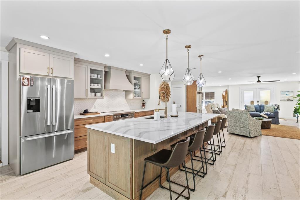506 58th Street Holmes Beach, FL 34217 - Photo 25 of 95 a kitchen with stainless steel appliances kitchen island granite countertop a table chairs and a refrigerator
