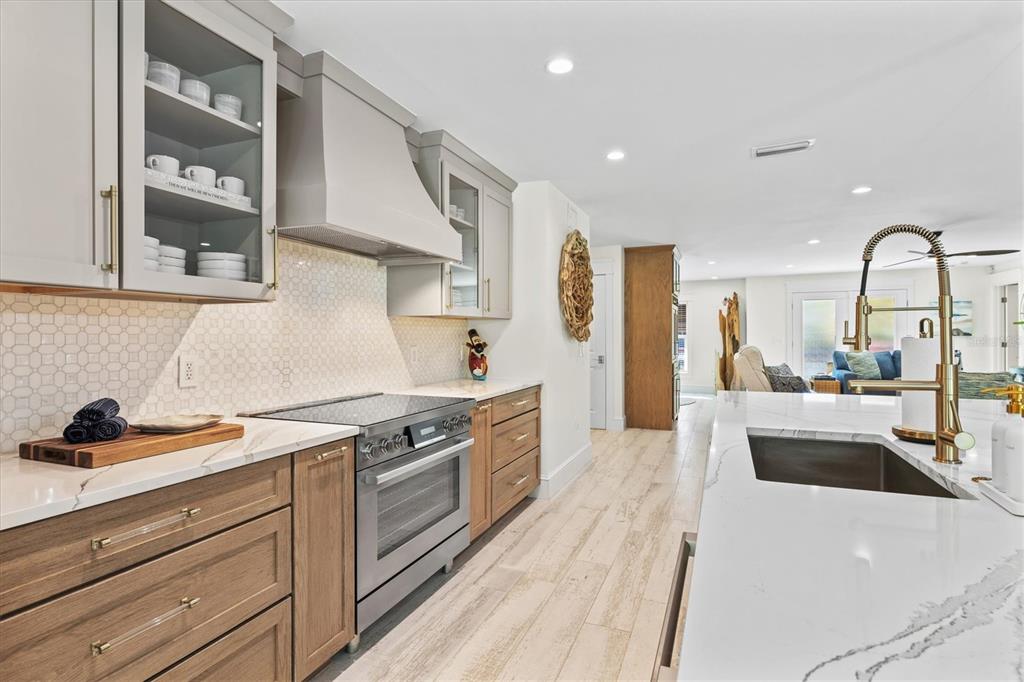 506 58th Street Holmes Beach, FL 34217 - Photo 26 of 95 a large kitchen with stainless steel appliances granite countertop a lot of counter space and wooden floors