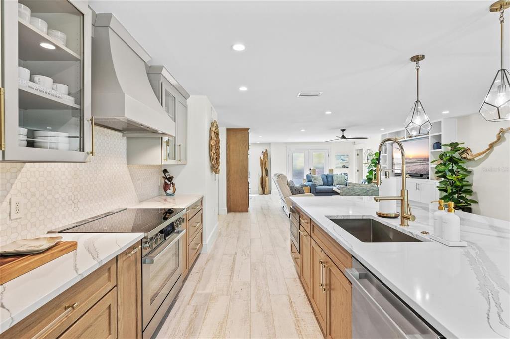 506 58th Street Holmes Beach, FL 34217 - Photo 27 of 95 a kitchen with stainless steel appliances granite countertop a sink a stove and a wooden floors