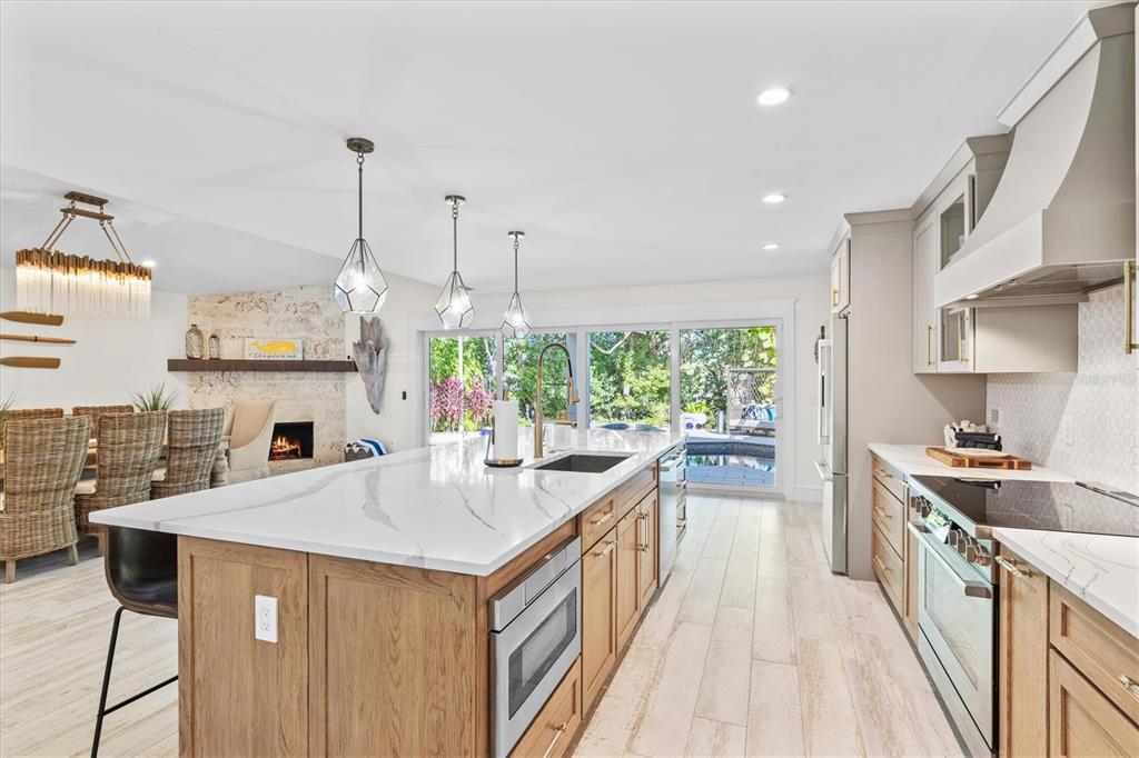 506 58th Street Holmes Beach, FL 34217 - Photo 28 of 95 a kitchen with a stove a sink a refrigerator and a wooden floor