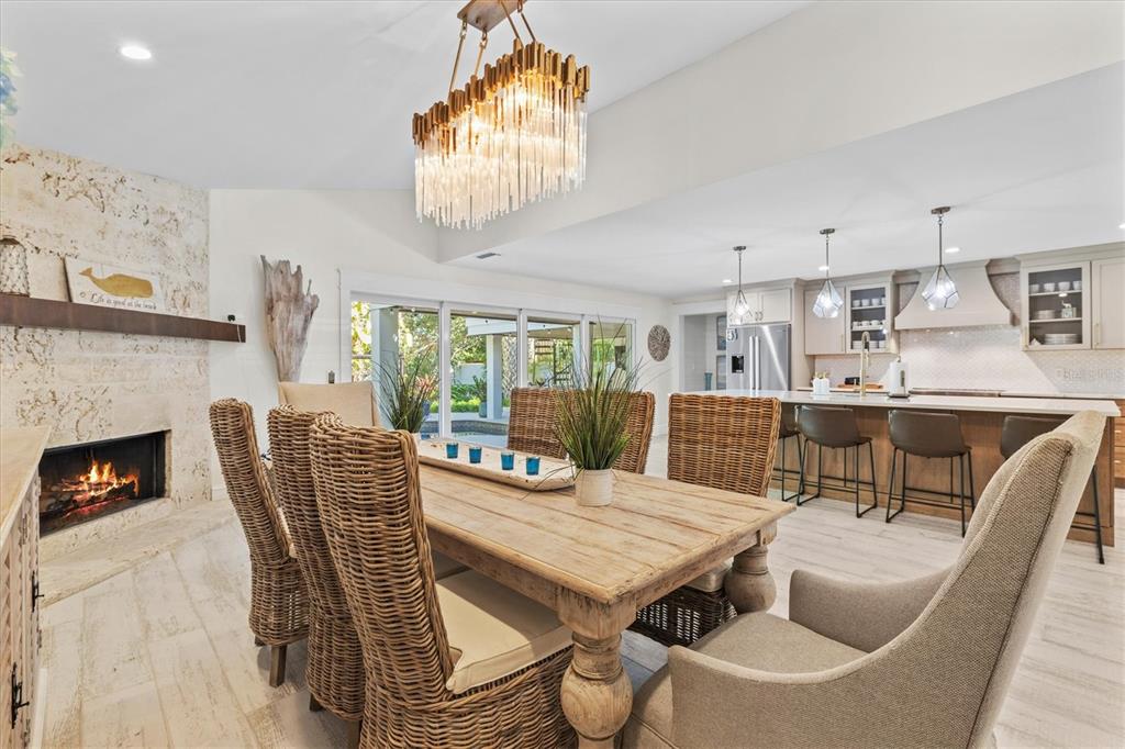 506 58th Street Holmes Beach, FL 34217 - Photo 32 of 96 a dining room with furniture a fireplace and wooden floor