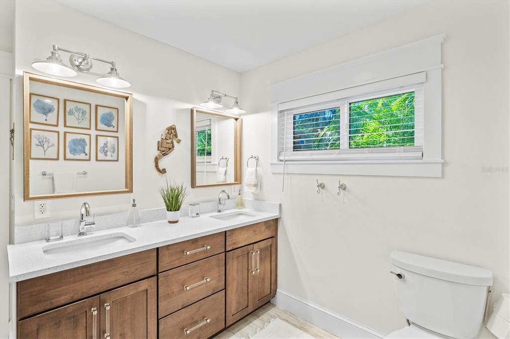 506 58th Street Holmes Beach, FL 34217 - Photo 43 of 95 a bathroom with a double vanity sink a mirror and a window