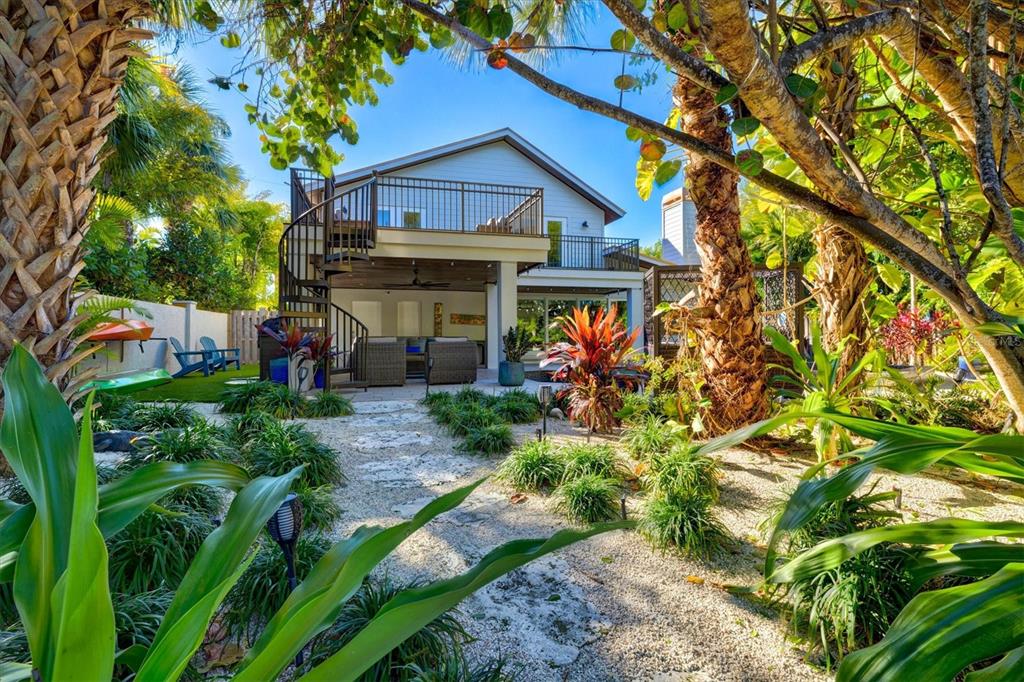 506 58th Street Holmes Beach, FL 34217 - Photo 7 of 95 a view of a house with a tree and plants