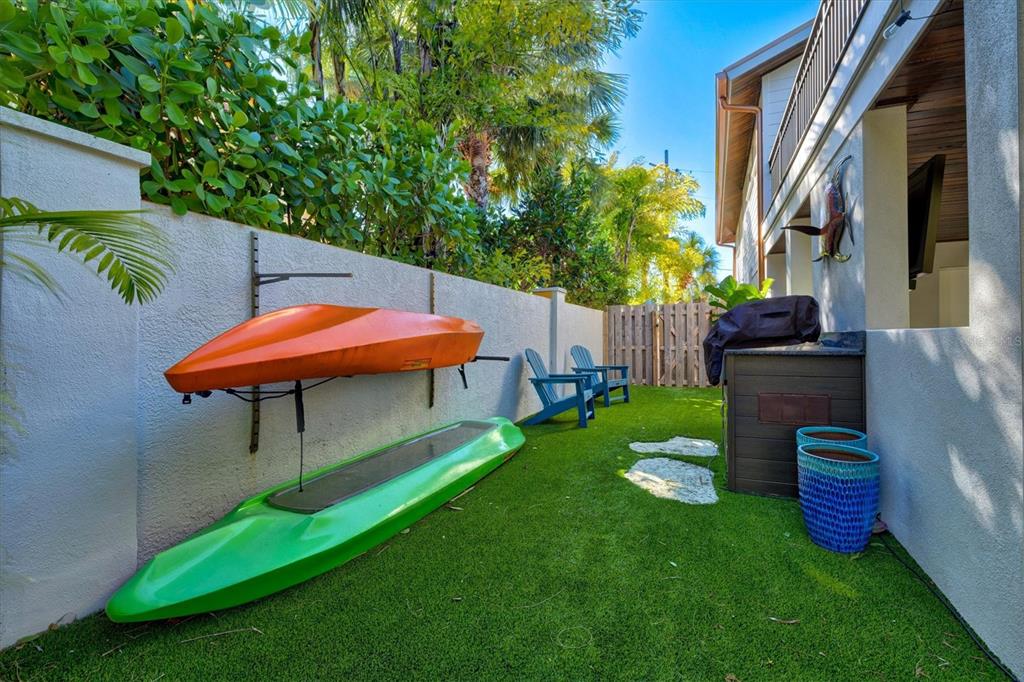 506 58th Street Holmes Beach, FL 34217 - Photo 93 of 96 a view of a backyard with table and chairs potted plants and wooden fence