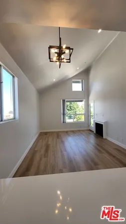 a view of empty room with wooden floor and ceiling fan