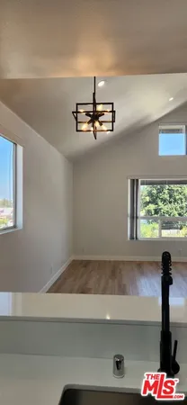 a view of empty room with kitchen