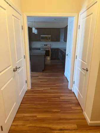 a hallway view with wooden floor and staircase