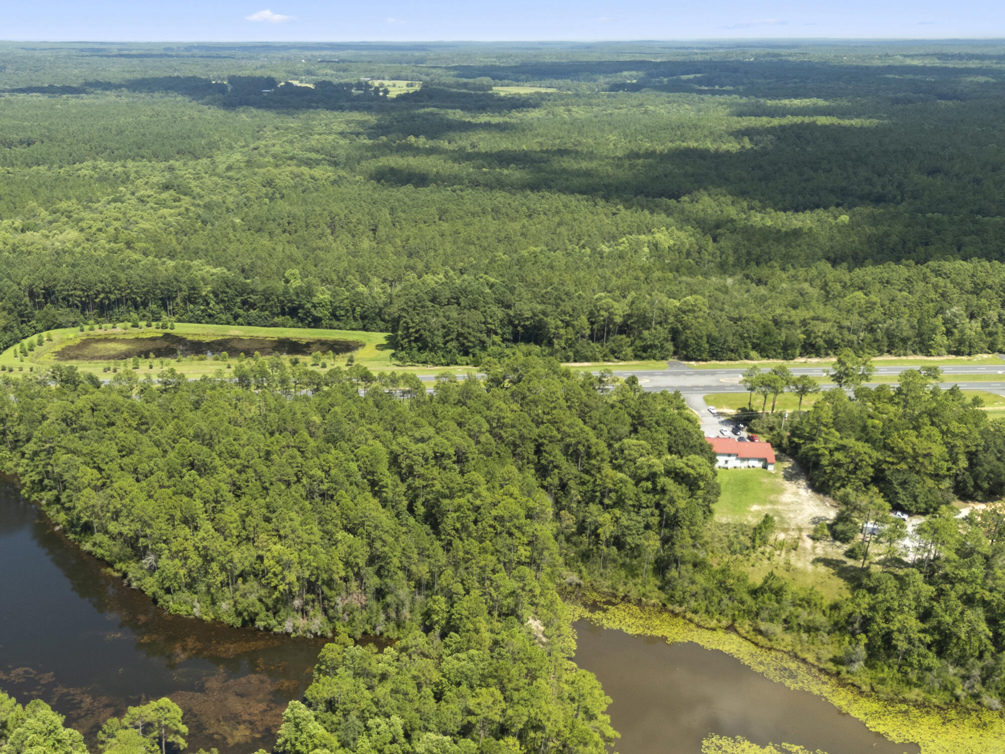 Lot 27 South Us Highway DeFuniak Springs, FL 32435 - Photo 10 of 12 a view of a lush green forest with a lake and trees