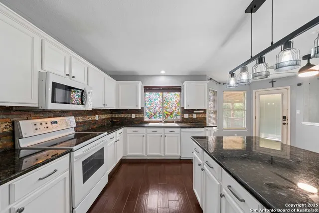 a kitchen with stainless steel appliances granite countertop a sink and cabinets