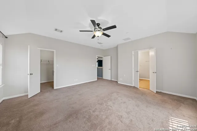 a view of an empty room with a ceiling fan
