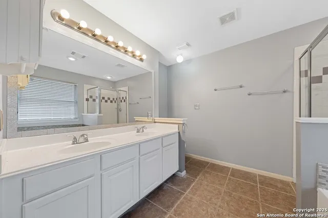 a spacious bathroom with a double vanity sink and a mirror