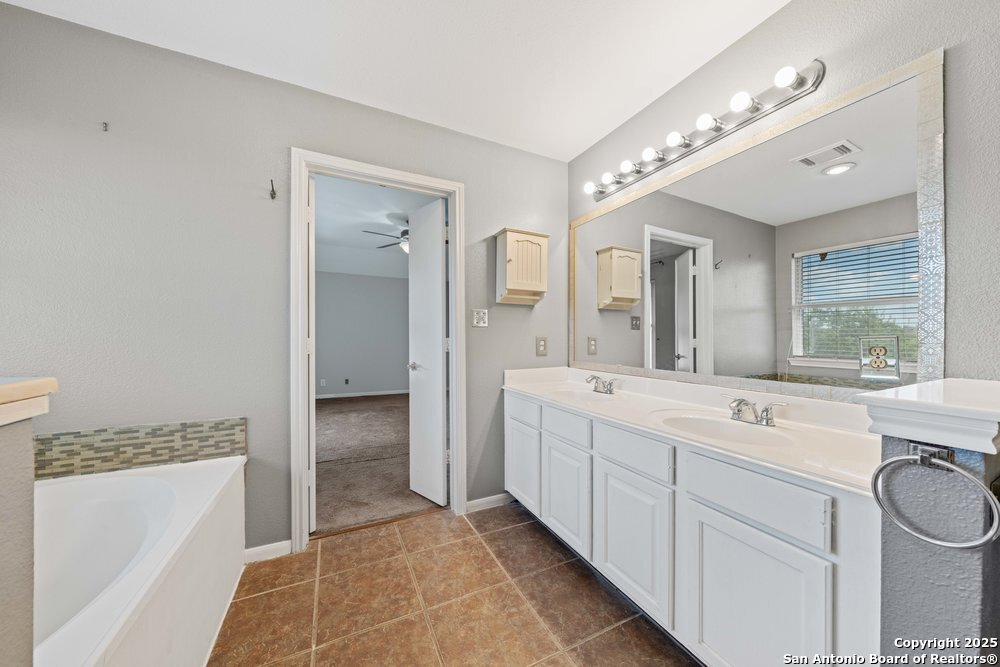 8411 Copperbluff Converse, TX 78109 - Photo 23 of 31 a spacious bathroom with a double vanity sink mirror and bathtub